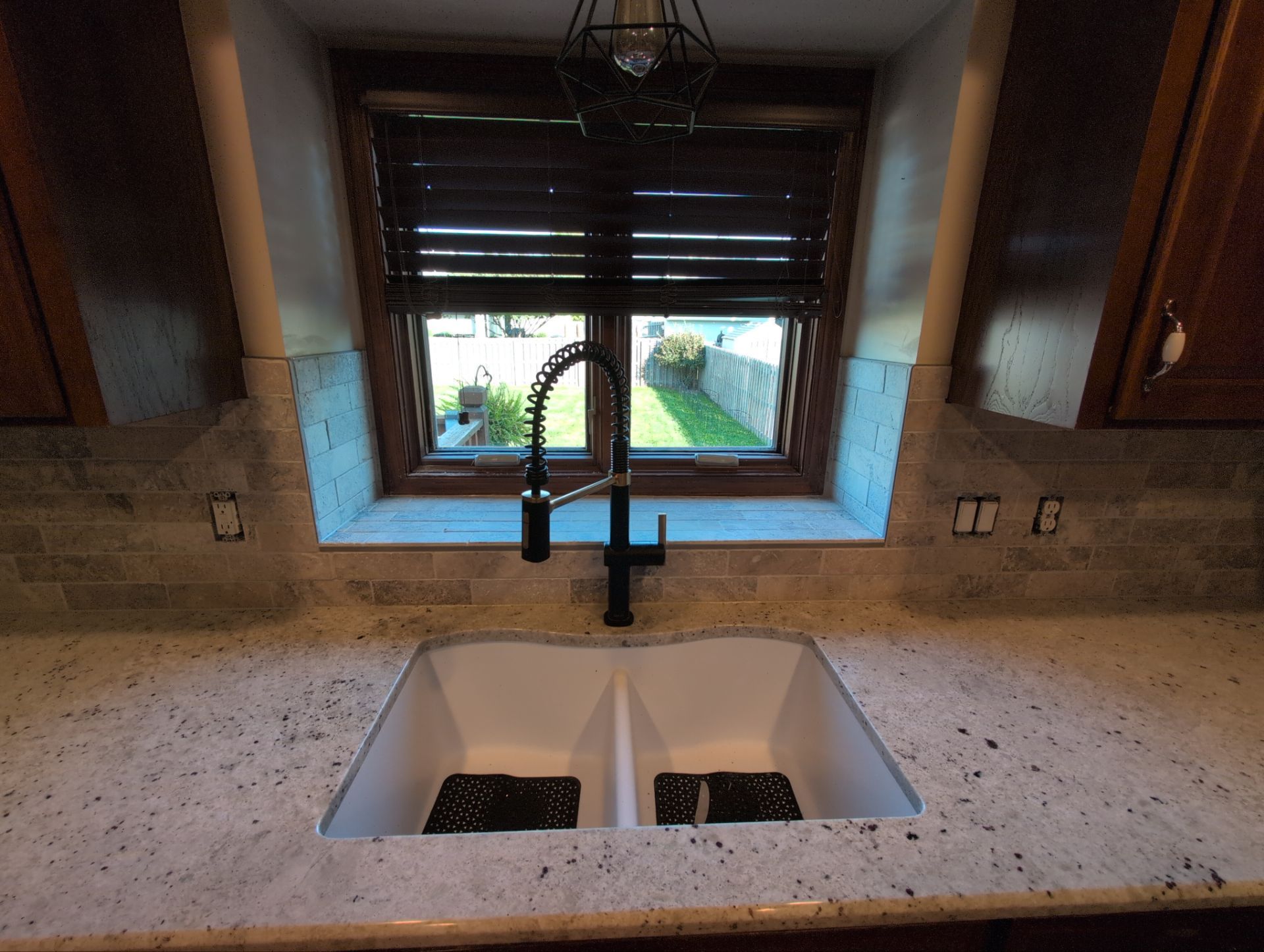 Natural stone tile wrapping sink area and window sill in Omaha kitchen