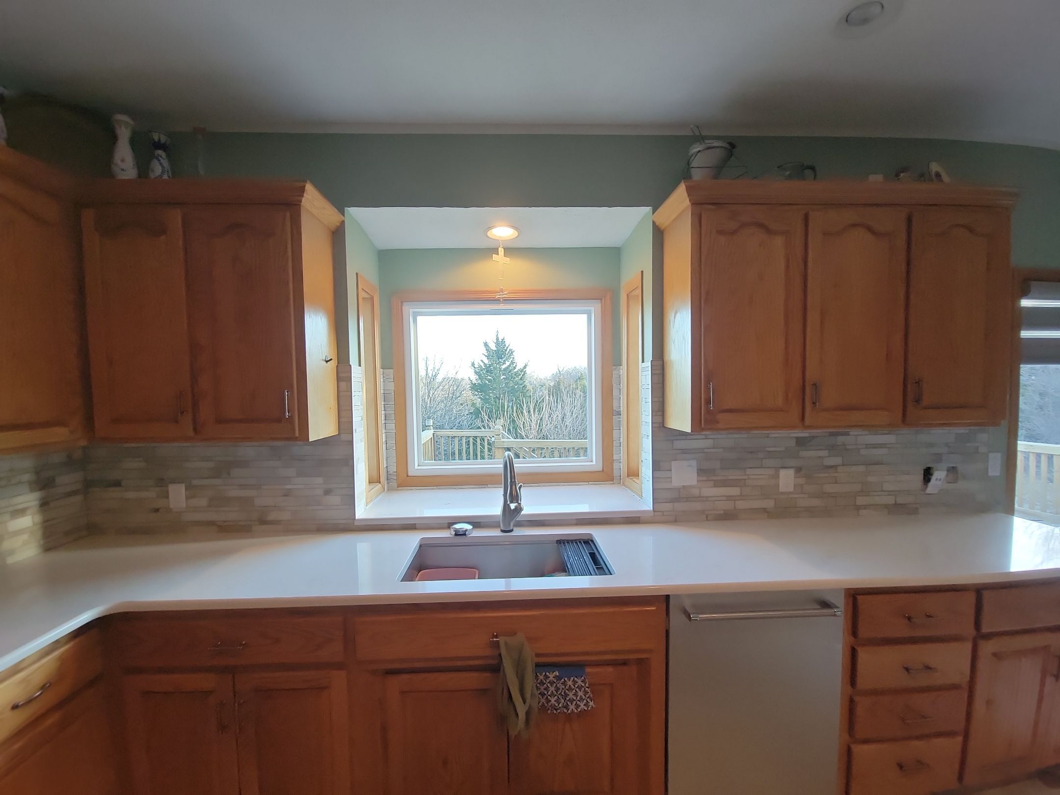 Natural stone mosaic backsplash with honey oak cabinets in Nebraska kitchen